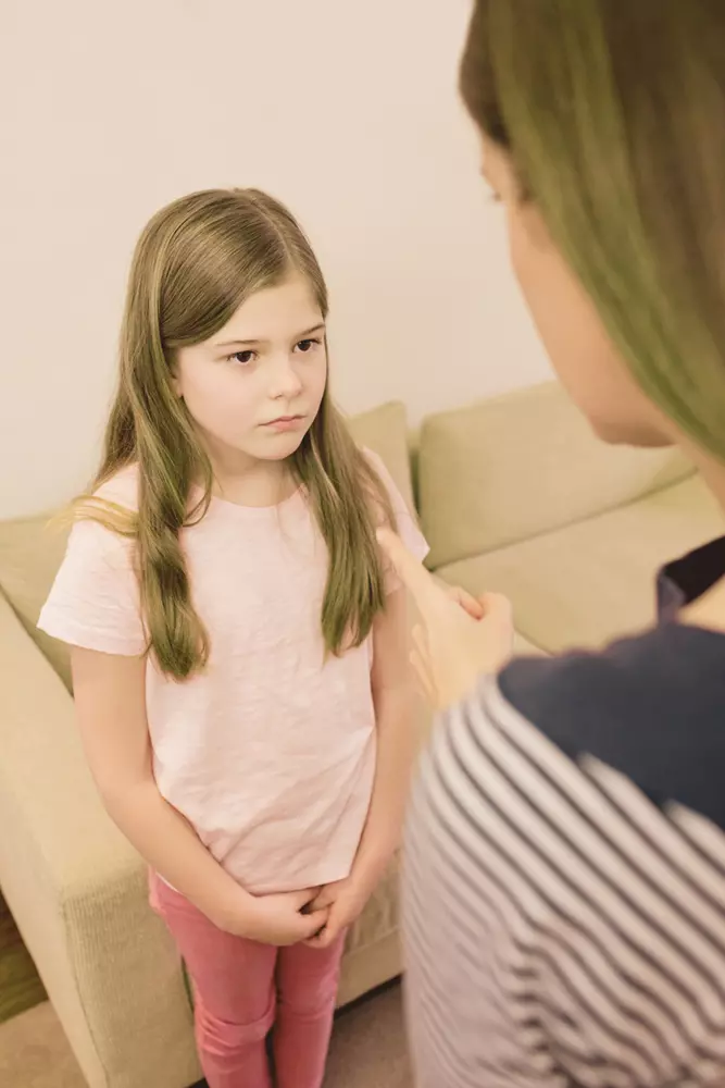 madre che rimprovera la figlia puntandole l'indice contro in segno di ammonimento