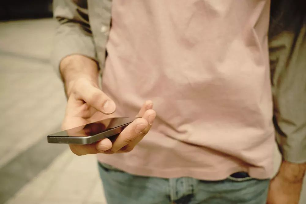 Uomo che tiene in mano un cellulare
