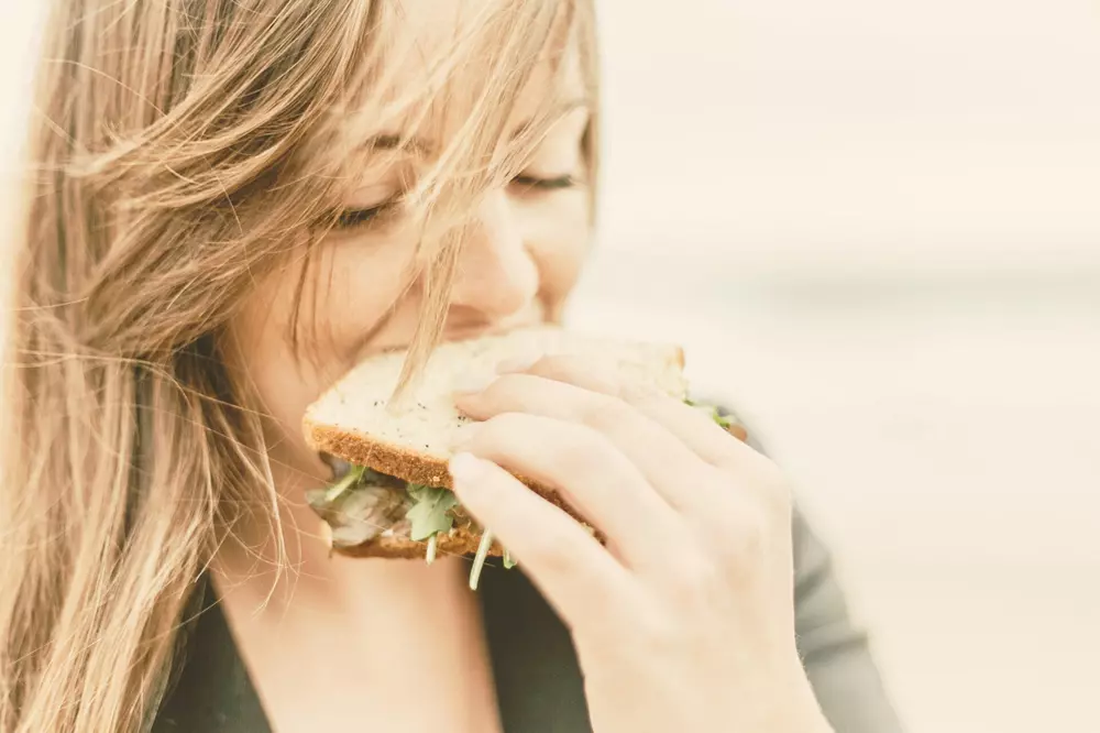 donna che mangia un toast con l'insalata