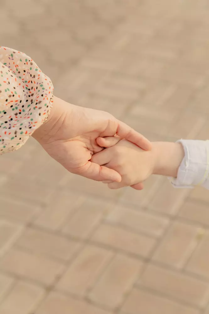 genitore e figlio che si tengono per mano