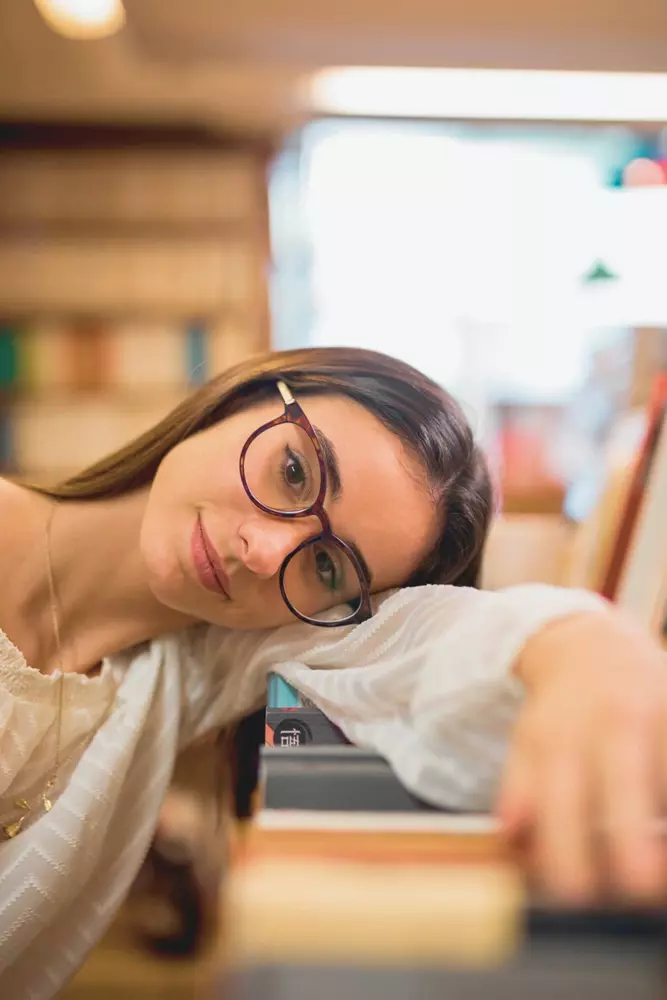 studentessa annoiata e demotivata con la testa posata sui libri